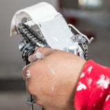 Close-up of hand adjusting mud loaded tape on Level 5 Automatic Taper at the job site