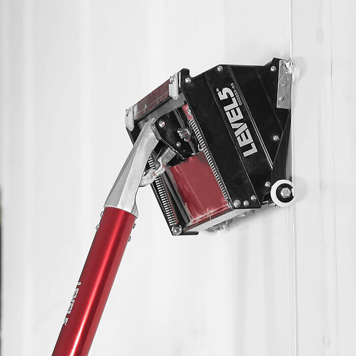 Side view of Level 5 flat box attached to a box handle applying finishing coat of mud to a wall joint